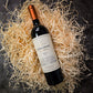 Bottle of Don David Reserve wine on a bed of straw with a dark background
